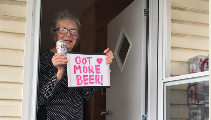 Olive Veronesi celebrates getting a stash of Coors Light with a sign that says, "Got More Beer!"