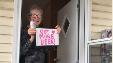 Olive Veronesi celebrates getting a stash of Coors Light with a sign that says, "Got More Beer!"